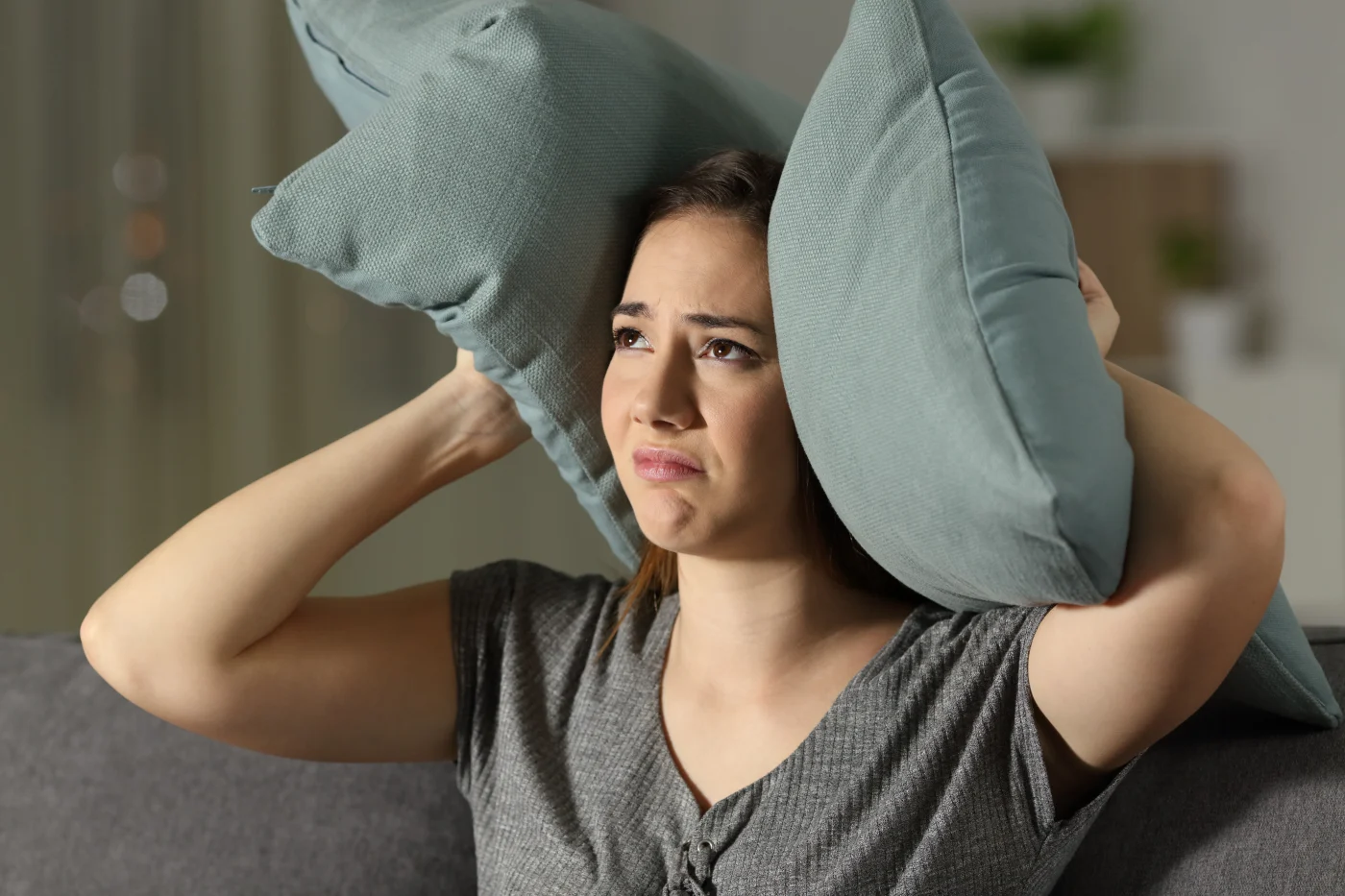 Twin Cities East Metro homeowner sits with pillows covering ears