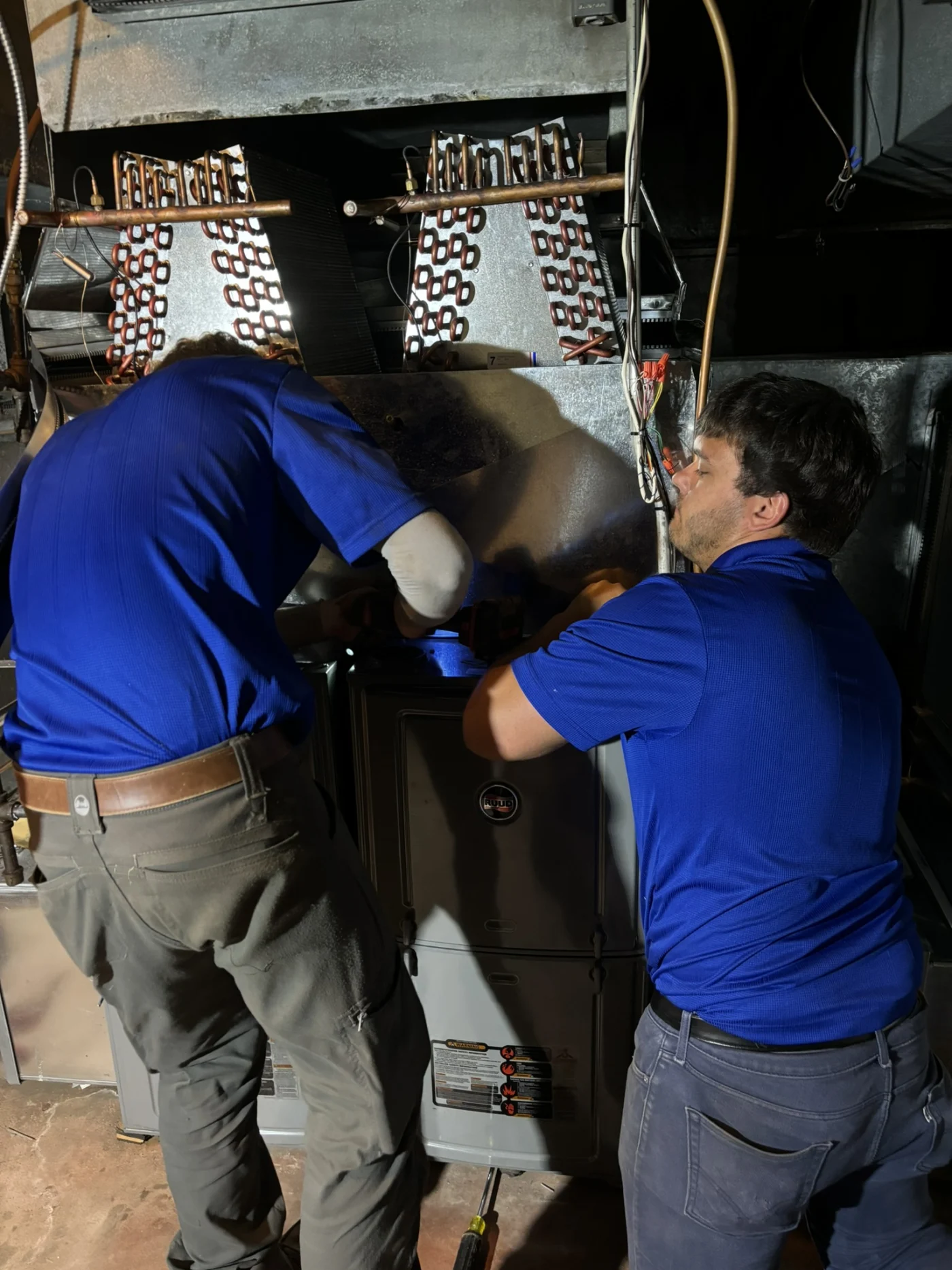 HVAC techs work on AC unit in East Twin Cities Metro