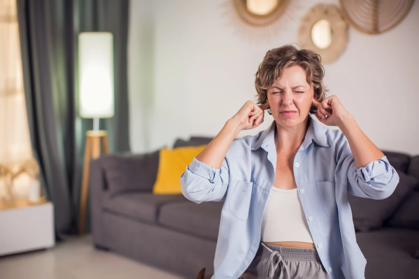 Twin Cities East Metro homeowner sits on couch closing ears