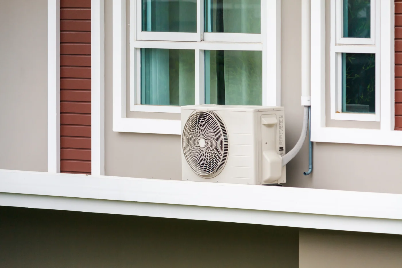 This image features a nice AC unit outside near the house's windows.