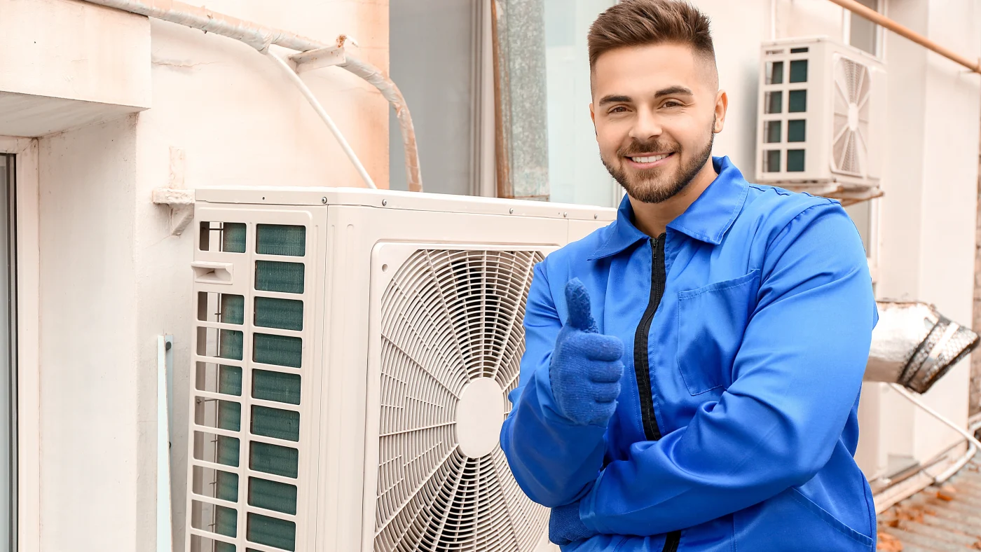 A/C technician giving a thumbs-up next to new a/c unit