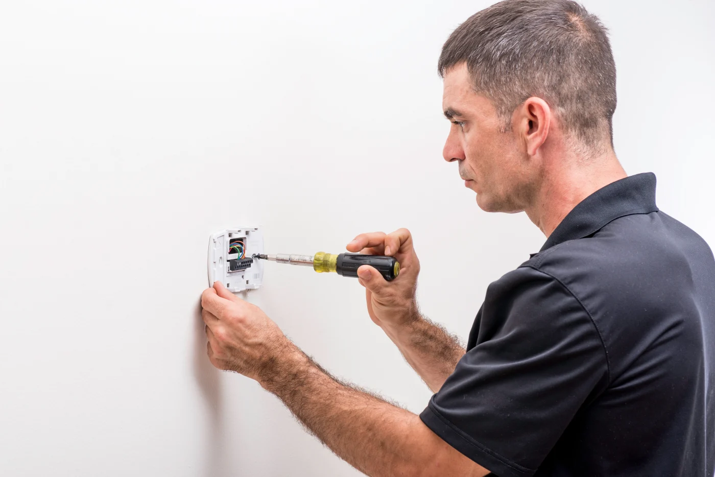 HVAC tech installing a new thermostat