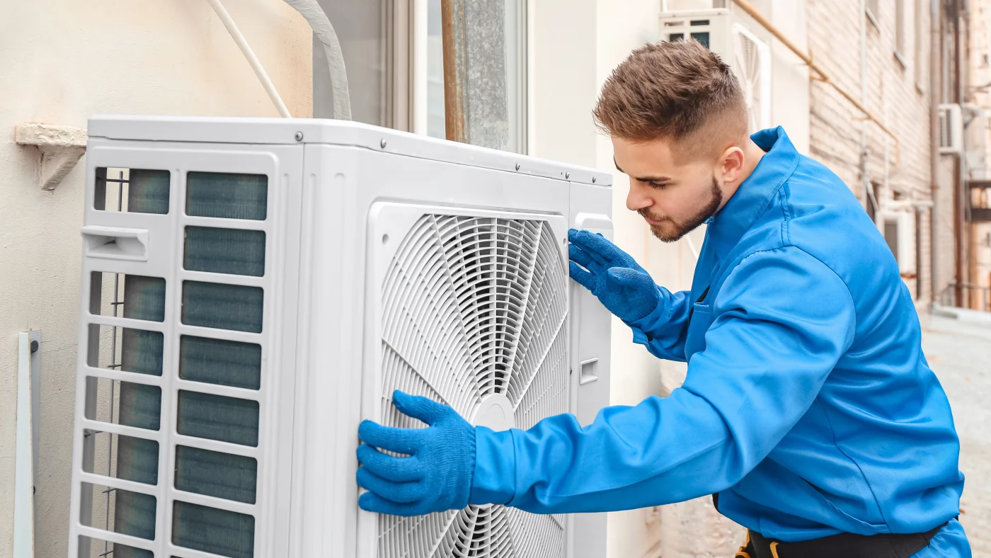 Technician installing new a/c unit outside Woodbury residence