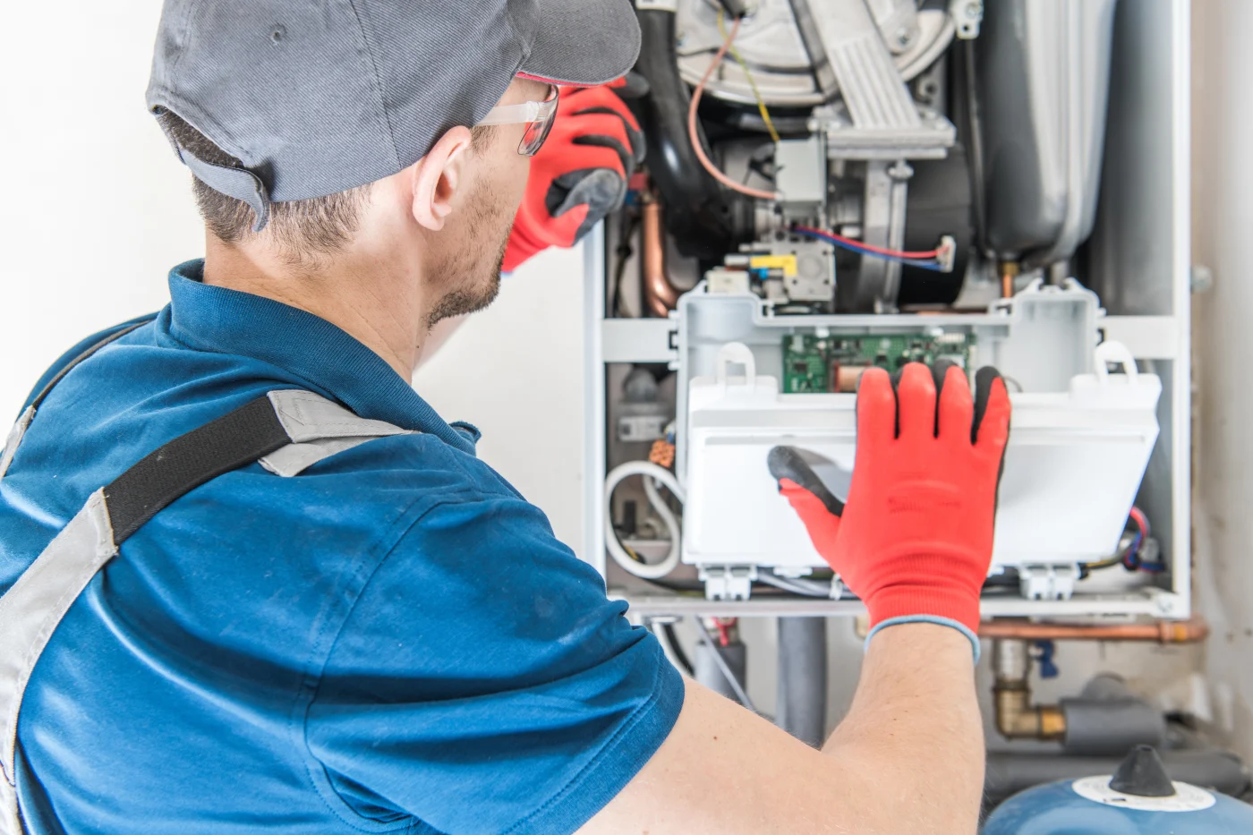 A professional contractor is working on the HVAC system in a house