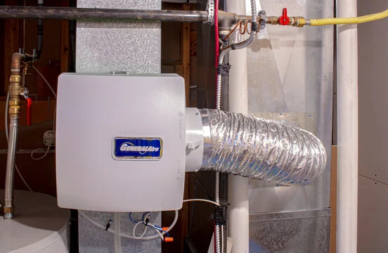 A woman is lying on a couch using a remote to adjust the HVAC system in her home