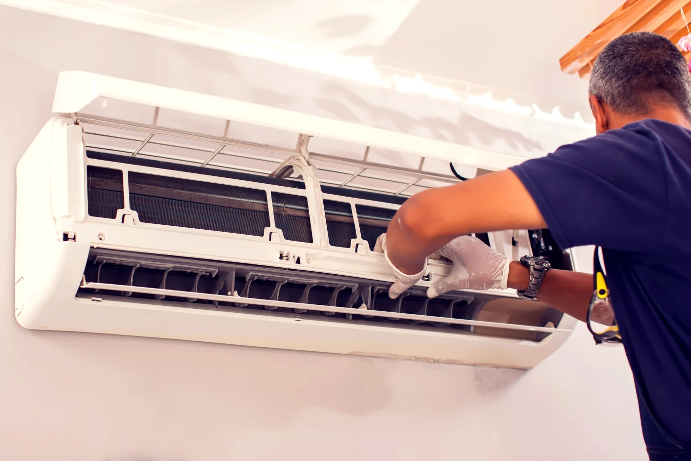 HVAC tech making repairs to indoor air conditioning