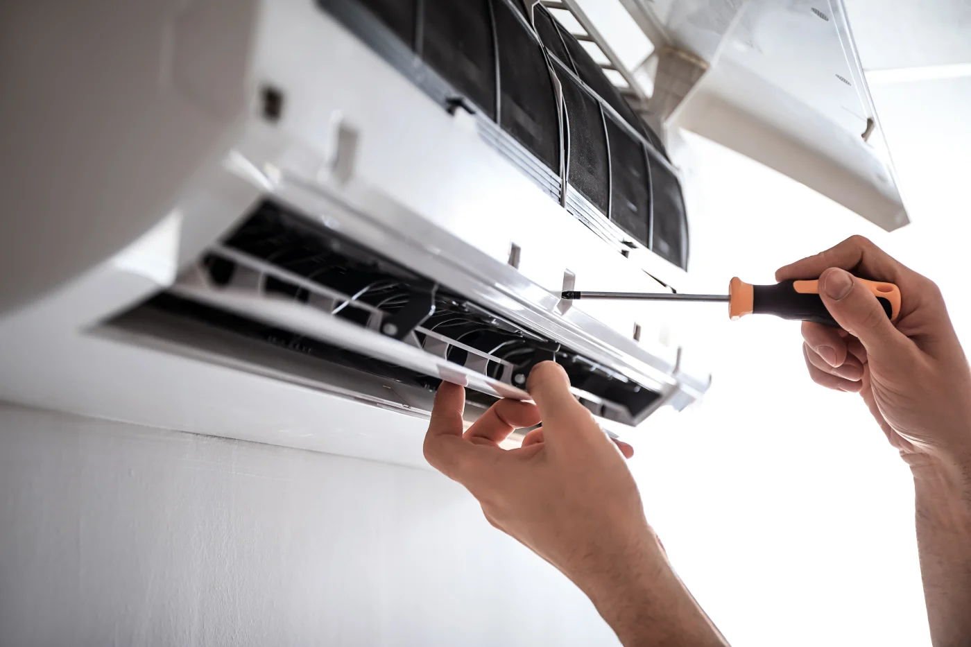 HVAC technician repairing a/c inside Oakdale, MN home