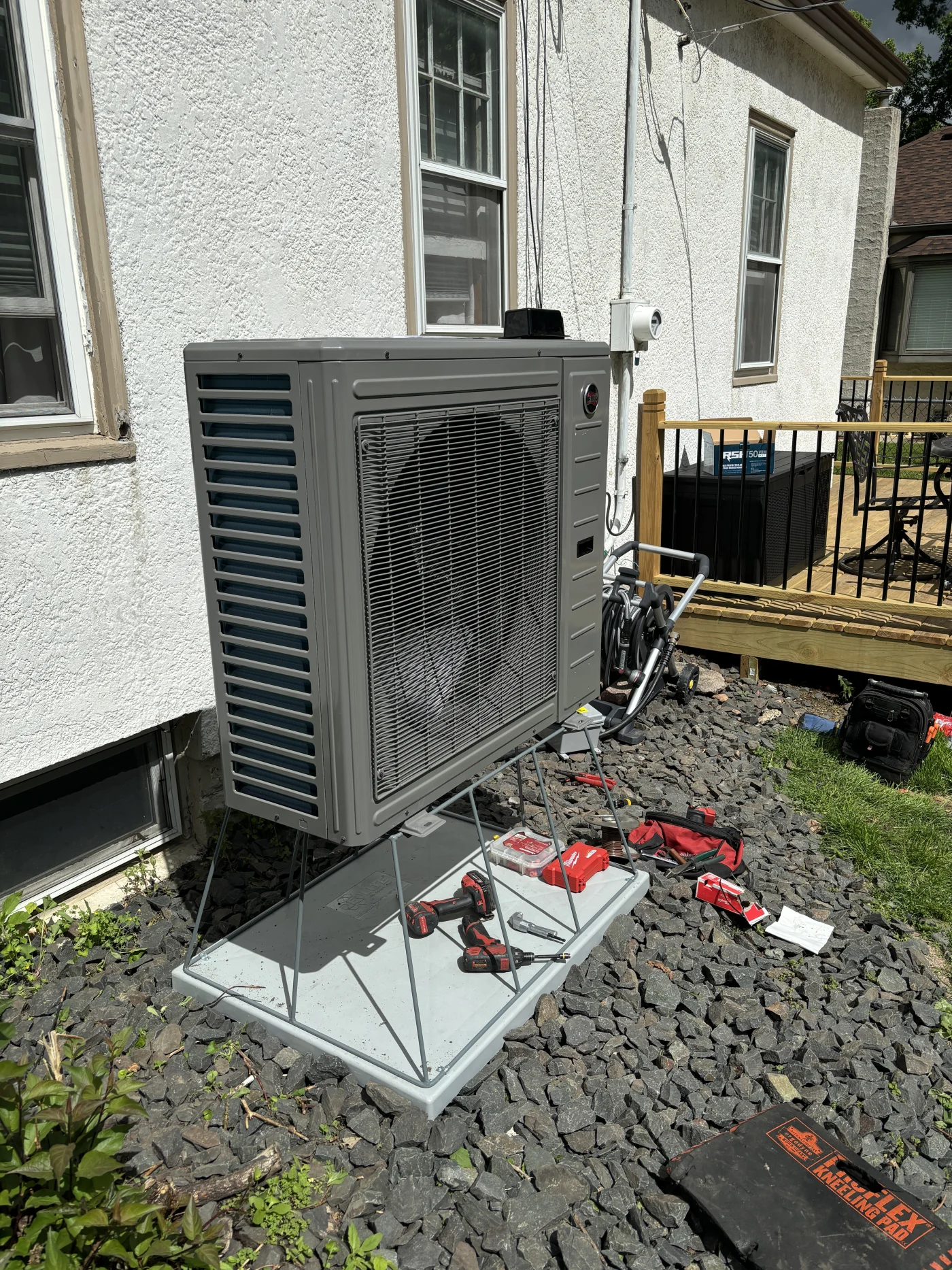 Effective heat pump installation featuring a newly mounted outdoor heat pump unit on a raised pad beside a stucco home.