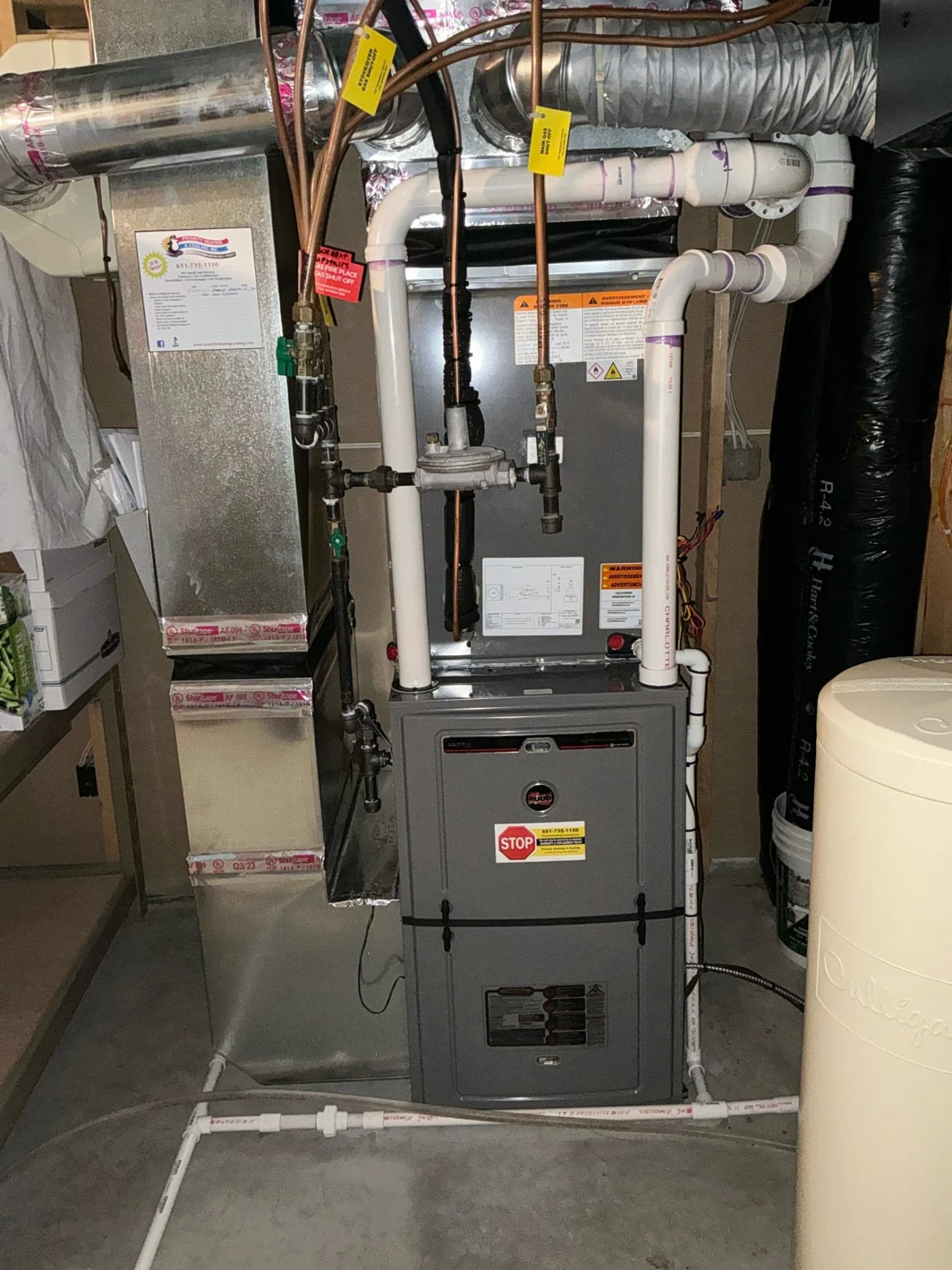 Impressive furnace replacement showing a newly installed high-efficiency gas furnace with connected ductwork, PVC venting, and copper lines.