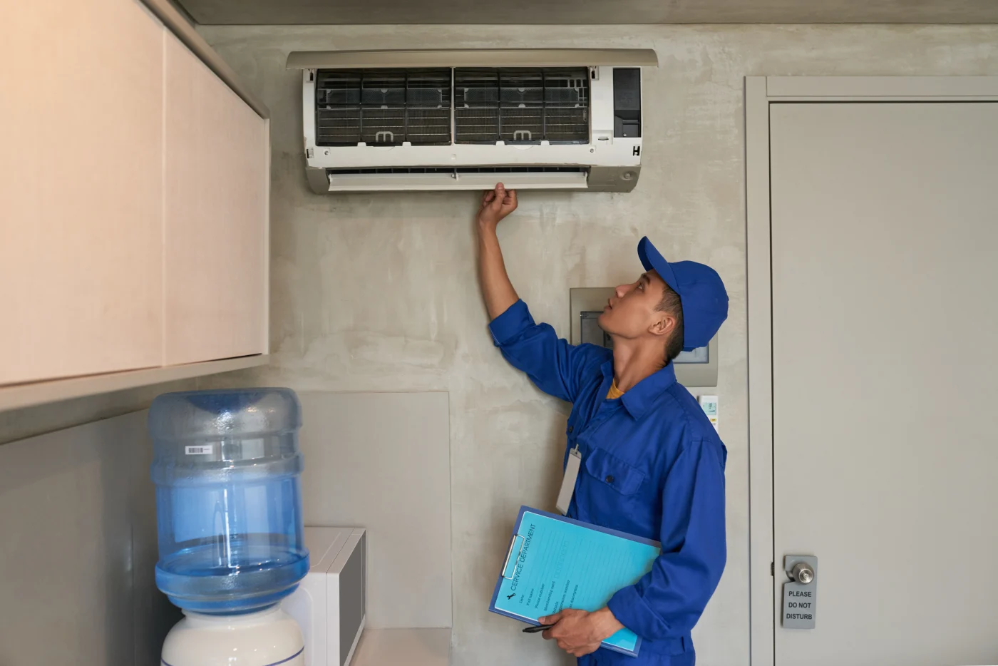 Technicians and air conditioning A professional looking at an AC unit to see if replacement is needed.