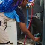 Technician performing AC services inside a home