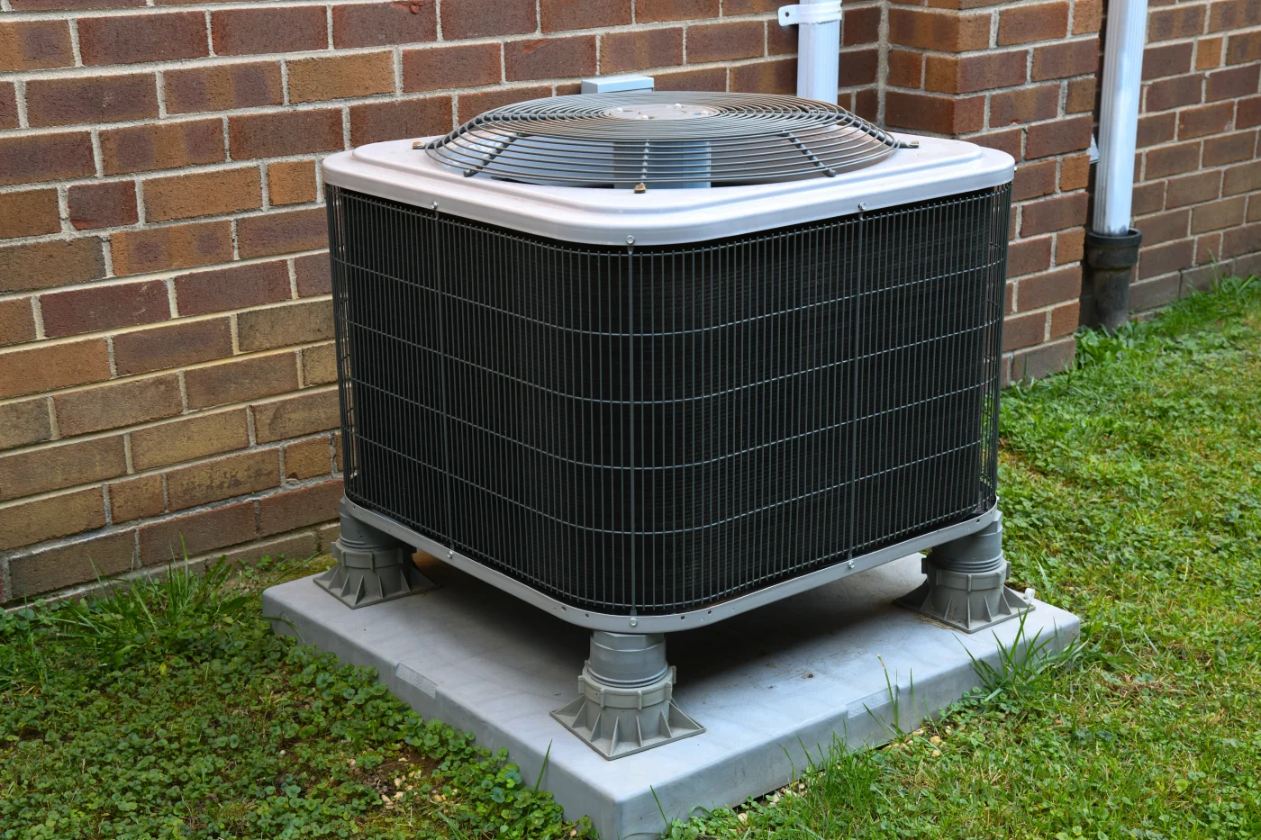 An outdoor AC unit installed on a pad to ensure optimal performance.